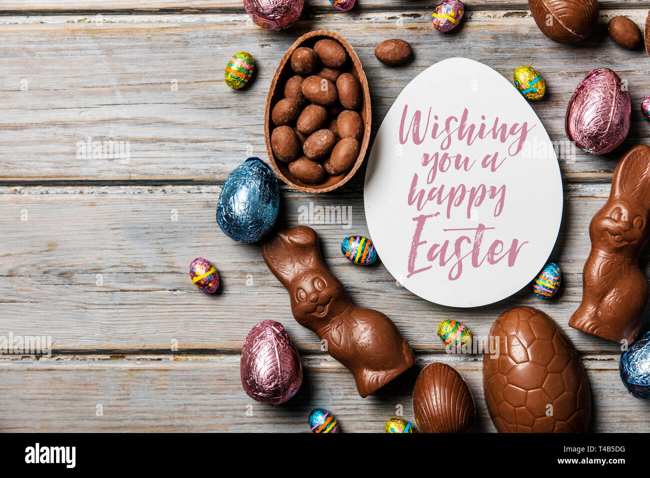 Les oeufs de pâques en chocolat et les lapins sur un fond de bois rustique Banque D'Images