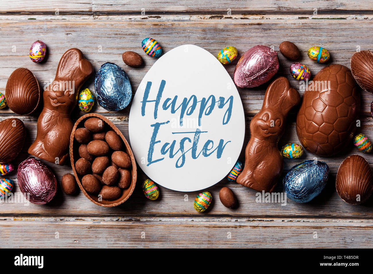 Les oeufs de pâques en chocolat et les lapins sur un fond de bois rustique Banque D'Images