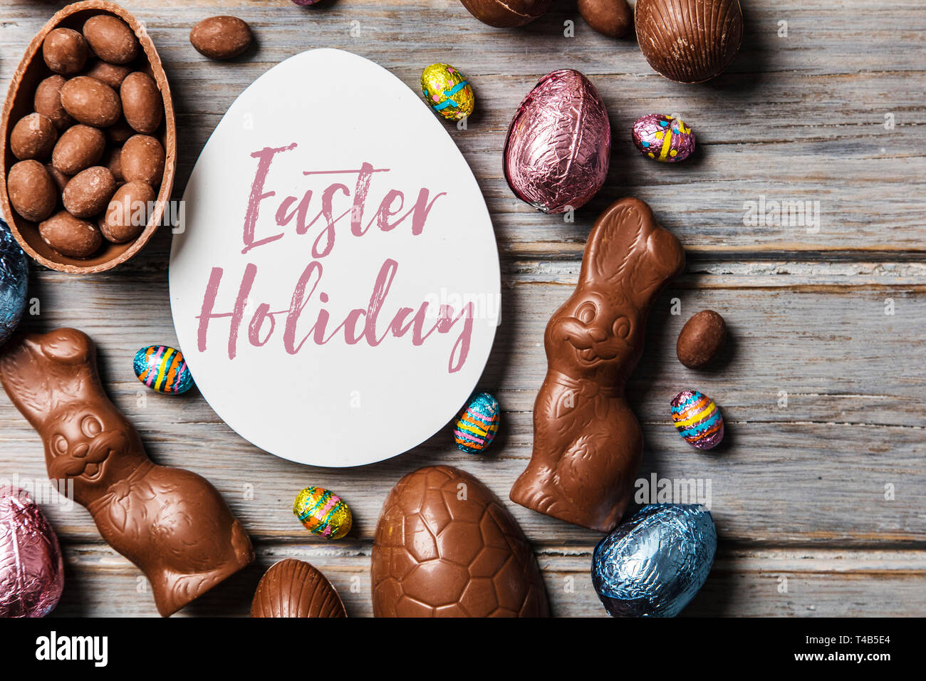 Les oeufs de pâques en chocolat et les lapins sur un fond de bois rustique Banque D'Images