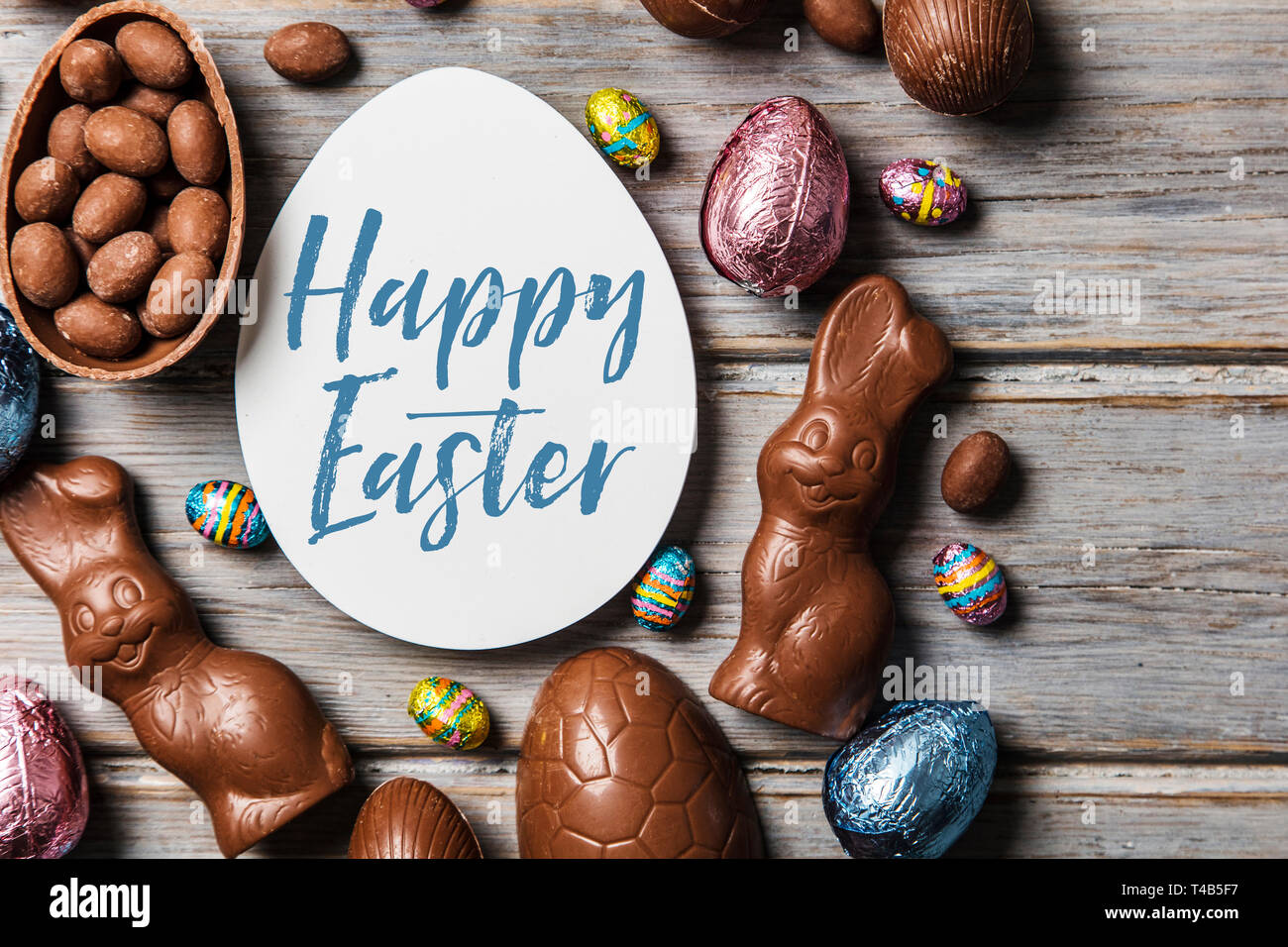 Les oeufs de pâques en chocolat et les lapins sur un fond de bois rustique Banque D'Images