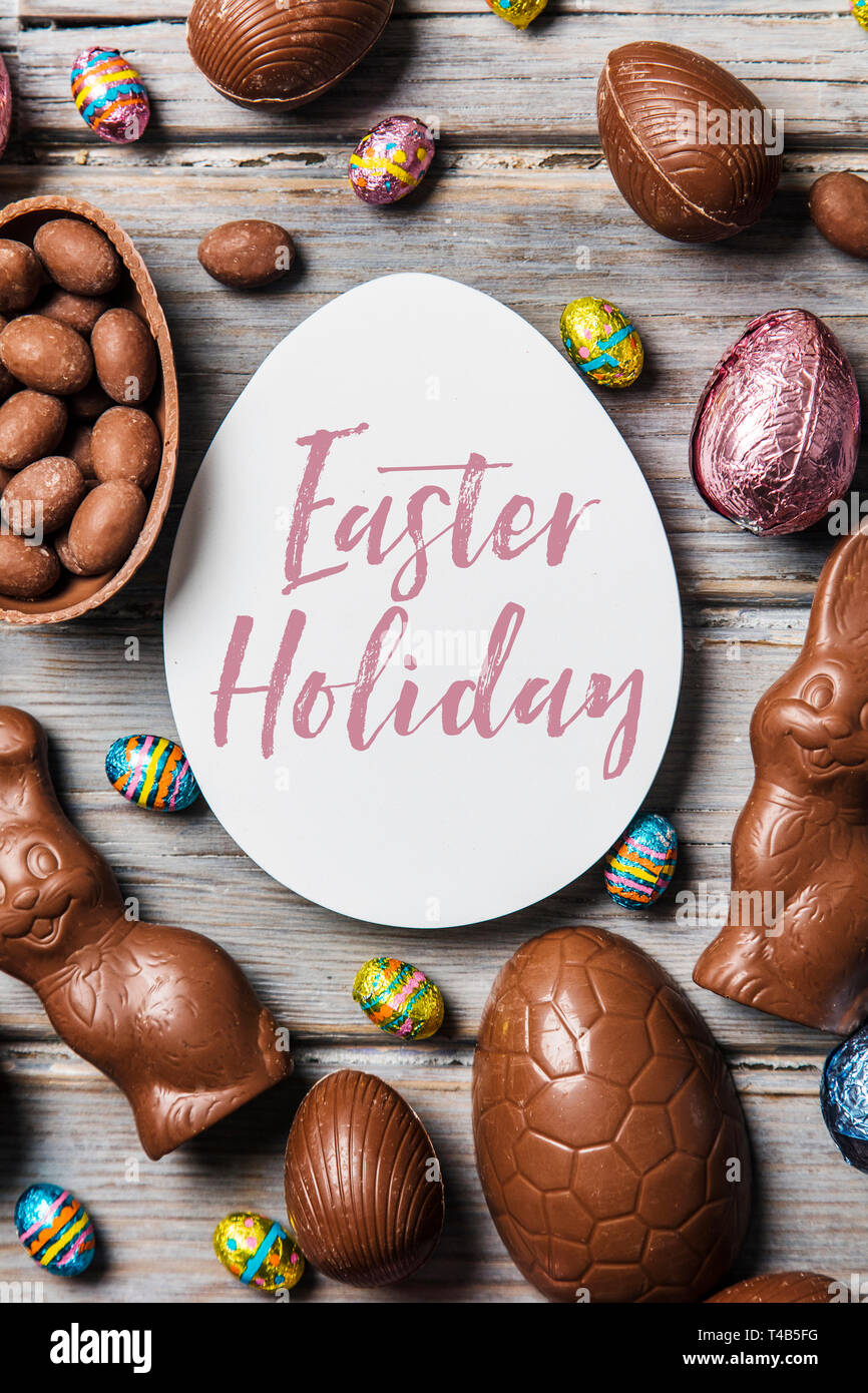 Les oeufs de pâques en chocolat et les lapins sur un fond de bois rustique Banque D'Images