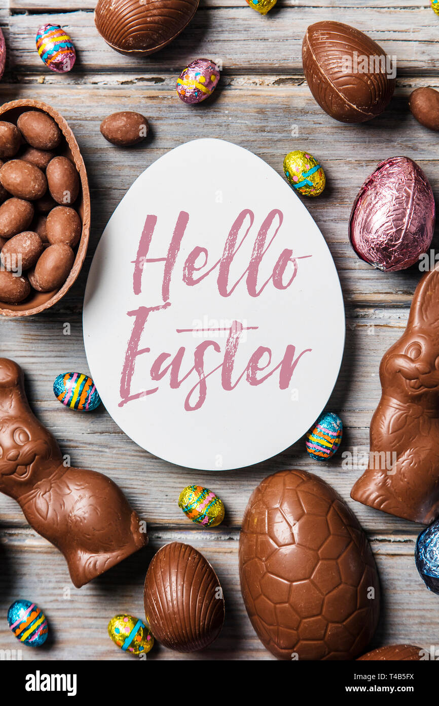 Les oeufs de pâques en chocolat et les lapins sur un fond de bois rustique Banque D'Images