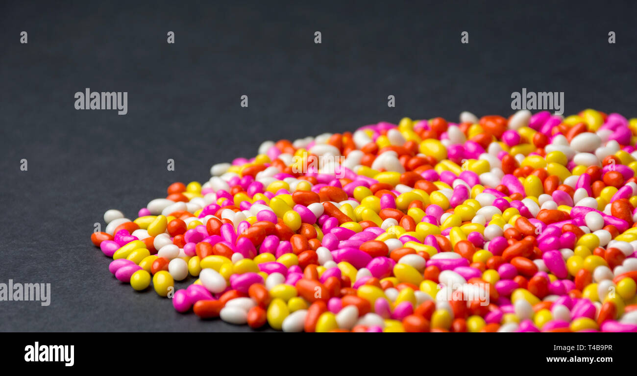 Arrière-plan coloré bonbon sucré chocolat multi couleur fond noir avec motif coloré isolé d'écran HD Banque D'Images