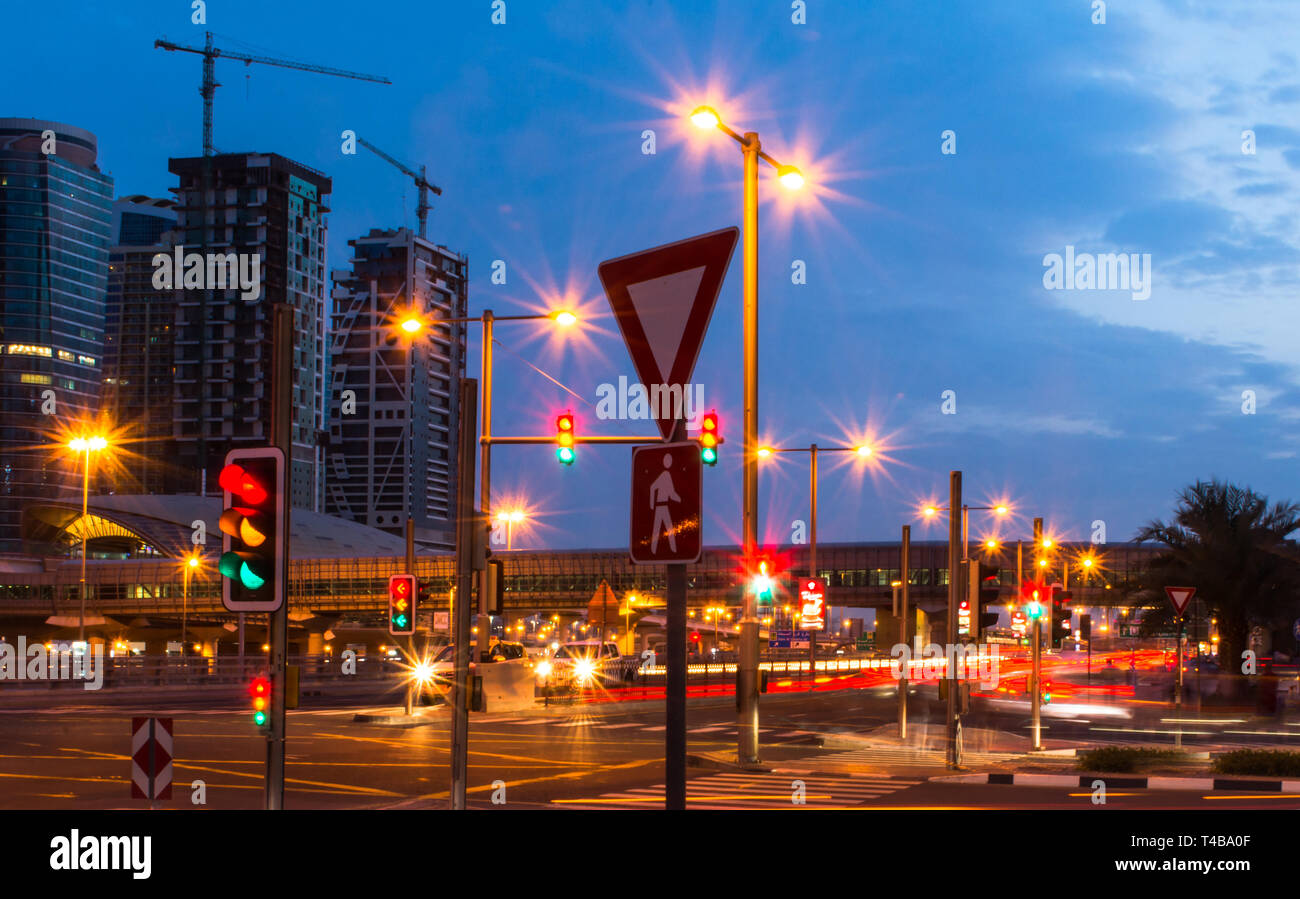 Des feux de circulation dans la ville de Dubaï en belle vue de nuit de la station de métro de Dubaï et bâtiments ciel bleu avec l'éclairage de rue Banque D'Images