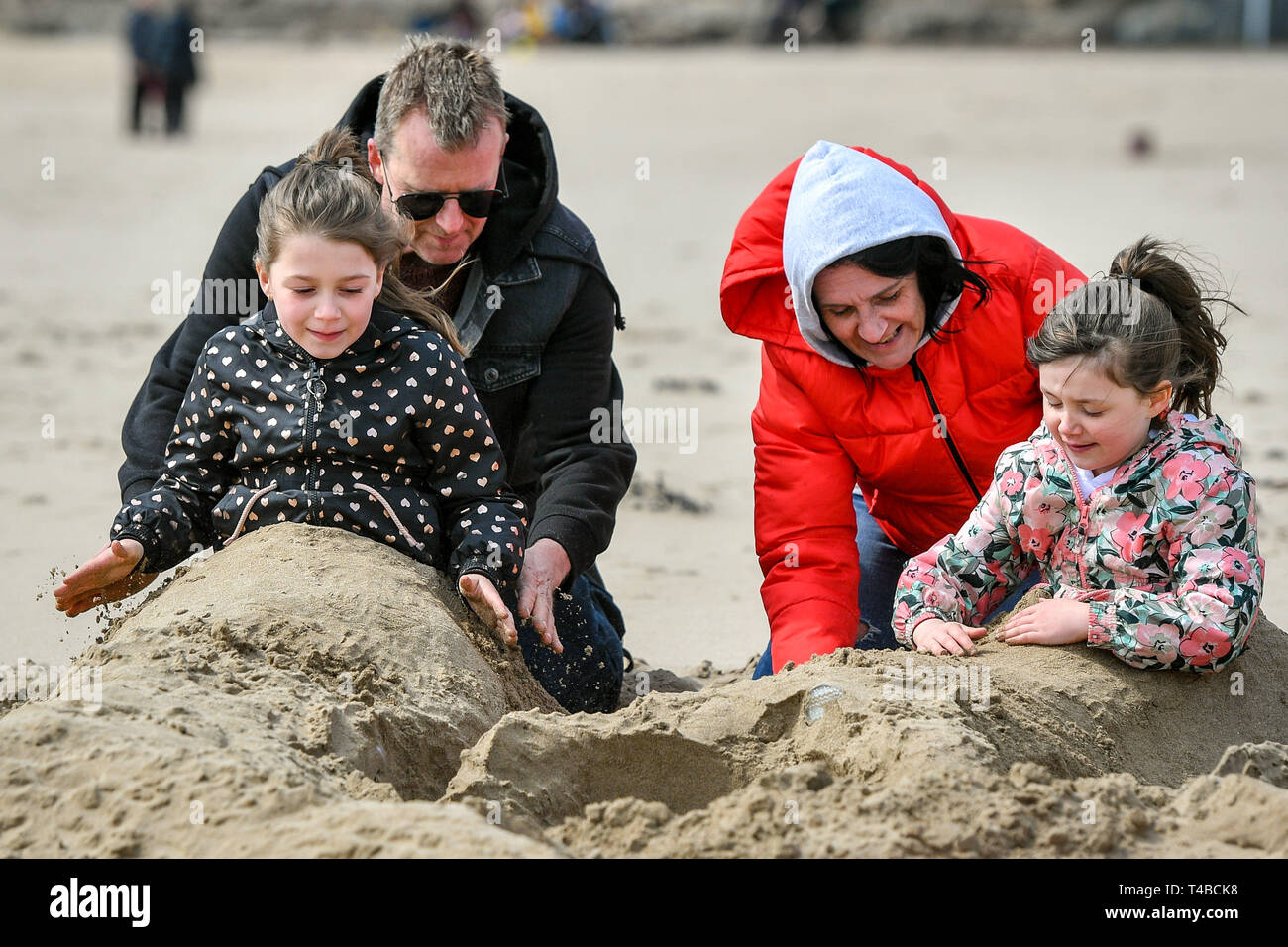 Ginette et Steve Ritchings de Swindon jouer avec leurs petits-enfants et faire la queue de sirène pour Lilly, 8, (à gauche) et Ava, 6, sur la plage de Barry Island, au Pays de Galles, que les températures au Royaume-Uni sont mis à augmenter à mesure que le week-end de Pâques approche. Banque D'Images
