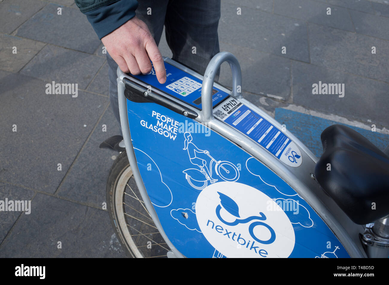 À l'aide clavier électronique pour déverrouiller un vélo libre-service Nextbike location à Glasgow, en Écosse. Banque D'Images