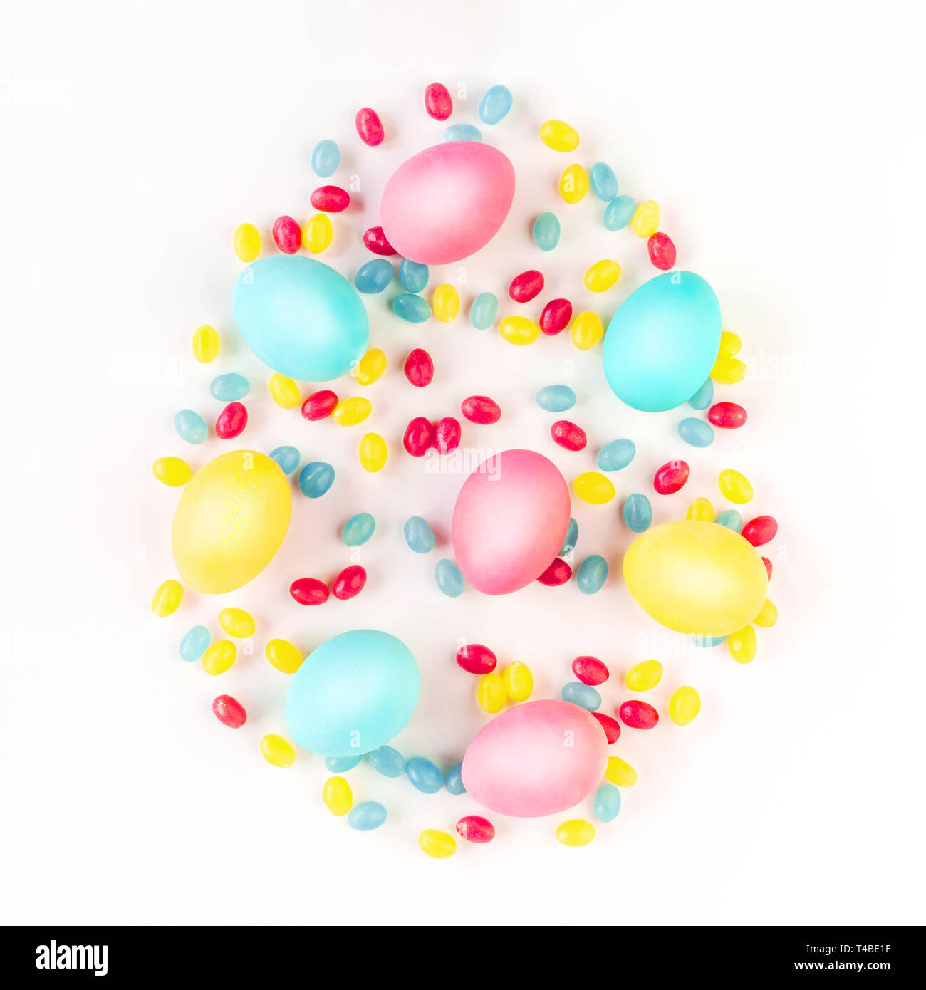 Concept d'œufs de Pâques. Oeufs colorés et bonbons isolées sur fond blanc. Mise à plat. Banque D'Images