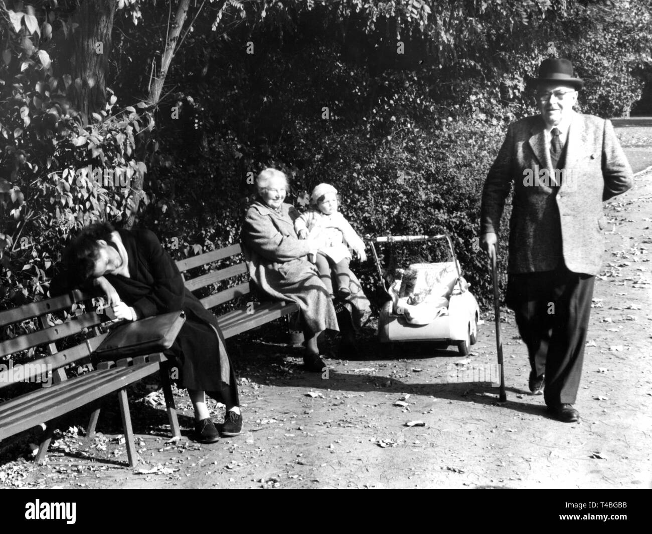 Dans le parc Bürgerpark, à Pankow (Berlin-Est), le 9 octobre 1957, les citoyens utilisent la journée ensoleillée d'automne de différentes façons : la sieste sur le banc de parc est tout aussi agréable qu'une promenade. Dans le monde d'utilisation | Banque D'Images