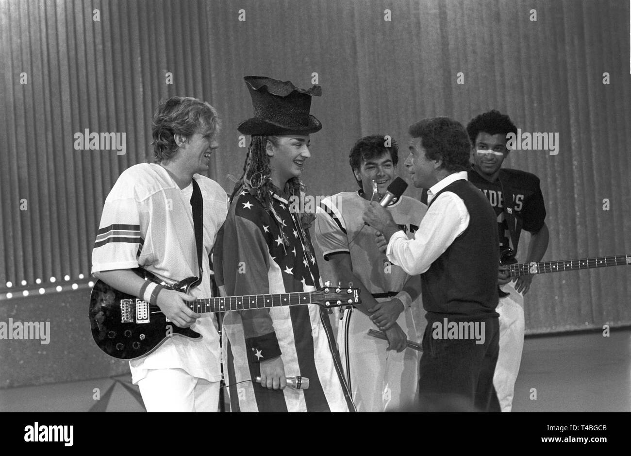 Modérateur Manfred Sexauer (r) en parlant de Boy George (milieu avec chapeau), le chanteur de le groupe pop britannique 'Culture Club', le 5 octobre 1983 à Hamilton au cours de l'enregistrement de l'émission pour l'attribution du 'Golden Europe'. Dans le monde d'utilisation | Banque D'Images