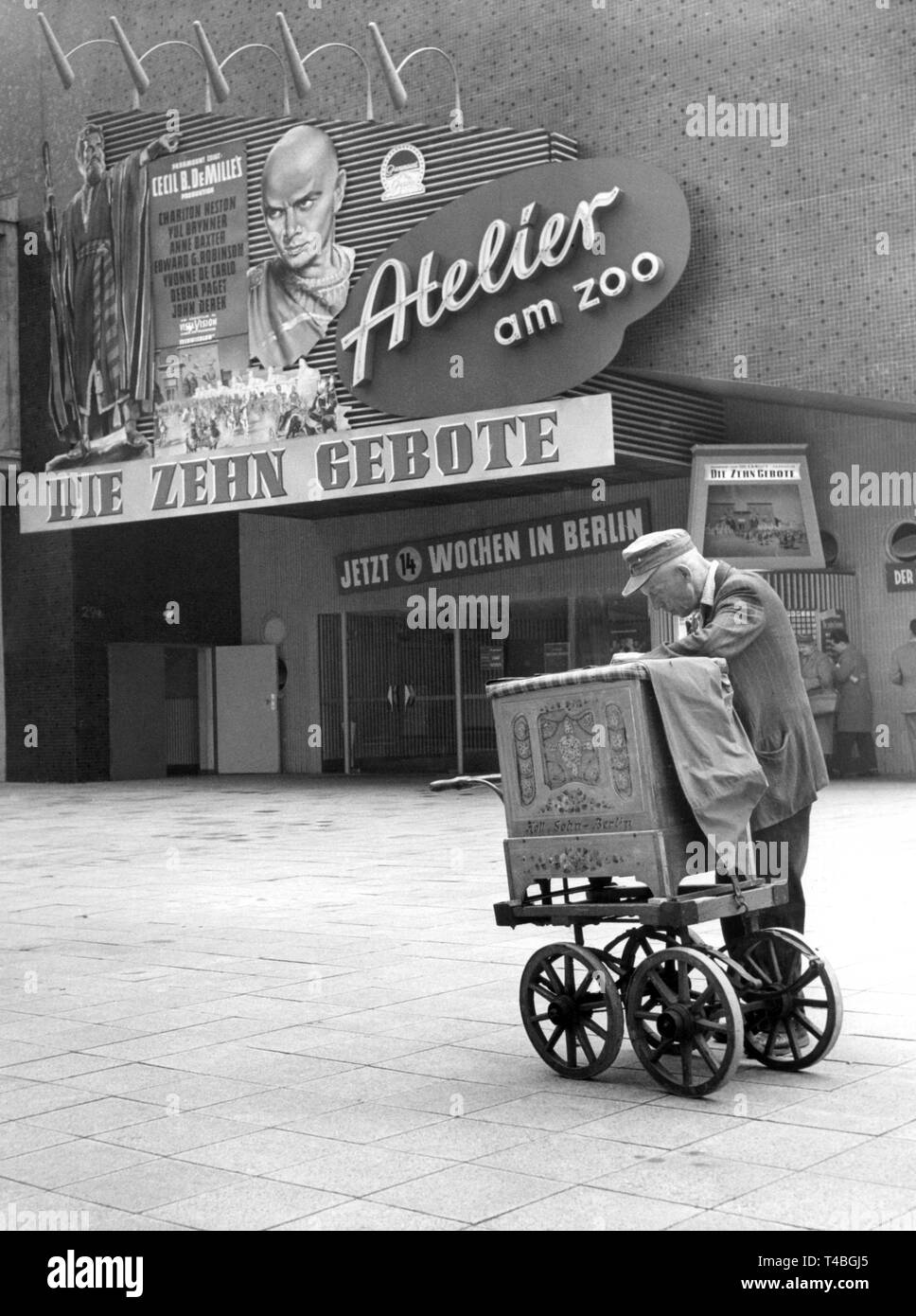 Un homme a placé lui-même avec son orgue en face du film 'Atelier théâtre am Zoo" à Berlin, où une publicité pour le film "Les Dix Commandements" avec Yul Brynner est illustré. (Mai 1958) | dans le monde entier Banque D'Images