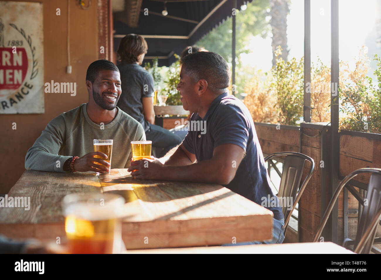 Deux amis en réunion Sports Bar bénéficiant d''un verre avant le match Banque D'Images