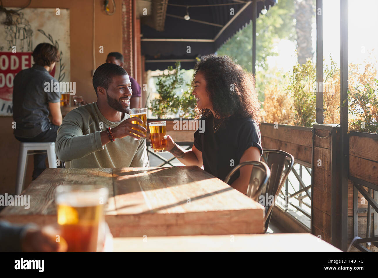 Jeune couple rencontre à Sports Bar bénéficiant d''un verre avant le match Banque D'Images