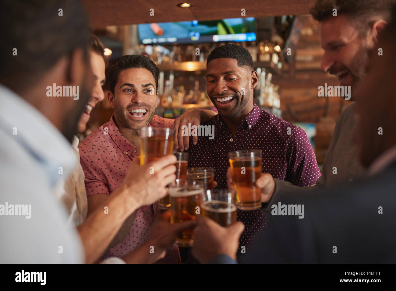 Groupe d'Amis sur Night Out de boire une bière au bar ensemble Banque D'Images