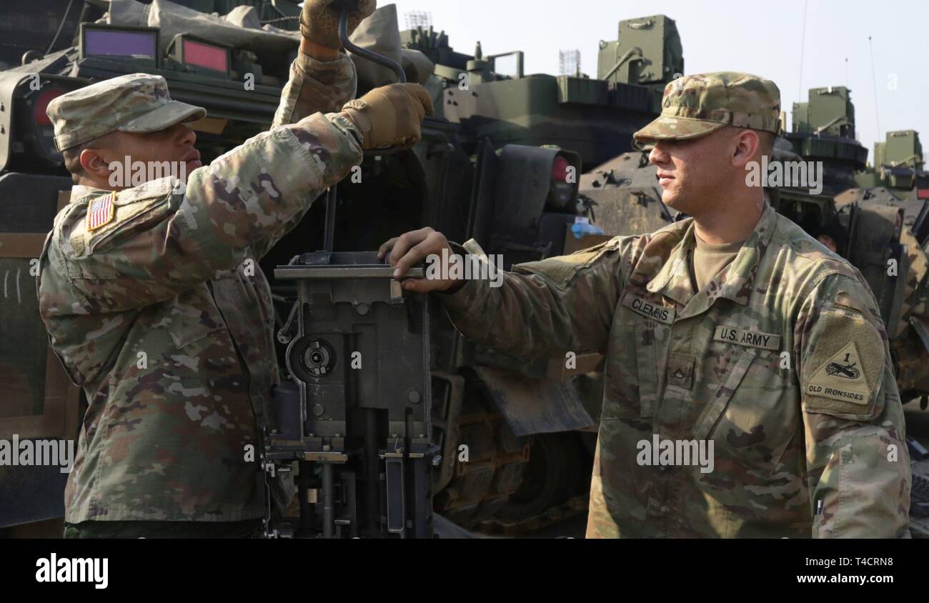 Le Sgt. Christopher Bell et la FPC. Damon Clemens, fantassins avec le 1er Bataillon, 6e Régiment d'infanterie, 2e Brigade Combat Team, 1re Division blindée, nettoyer le canon de 25 mm M242 à partir de la Chambre le M2 Bradley Véhicule de combat au cours de la préparation du terrain pour un exercice de préparation au déploiement d'urgence Drawsko Pomorskie, Pologne, Région de formation le 23 mars. Sous la direction du secrétaire de la Défense, la 2ème Armored Brigade Combat Team, 1re Division blindée, déployée à l'Europe d'exercer la capacité de l'armée américaine d'alerte rapide, de rappel et de déployer dans des conditions d'urgence. Les forces américaines déployées à l'E Banque D'Images