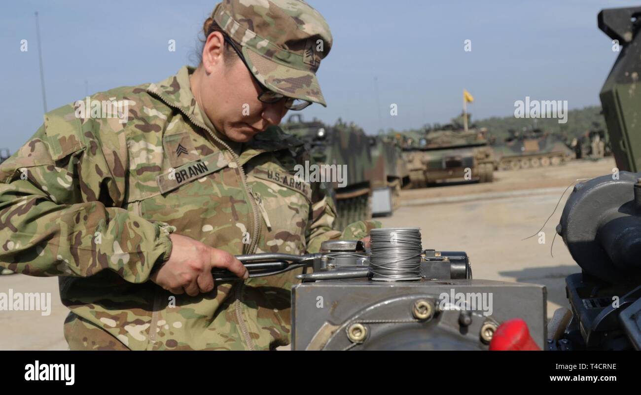 Le Sgt. Valarie Brann, un petit calibre/ réparateur d'artillerie avec le 1er Bataillon, 6e Régiment d'infanterie, 2e Brigade Combat Team, 1re Division blindée, les réparations du capot de la M242 25mm gun chambre pendant la préparation du terrain pour un exercice de préparation au déploiement d'urgence Drawsko Pomorskie, Pologne, Région de formation le 23 mars. Sous la direction du secrétaire de la Défense, la 2ème Armored Brigade Combat Team, 1re Division blindée, déployée à l'Europe d'exercer la capacité de l'armée américaine d'alerte rapide, de rappel et de déployer dans des conditions d'urgence. Les forces américaines déployées en Europe en soutien de l'E Banque D'Images