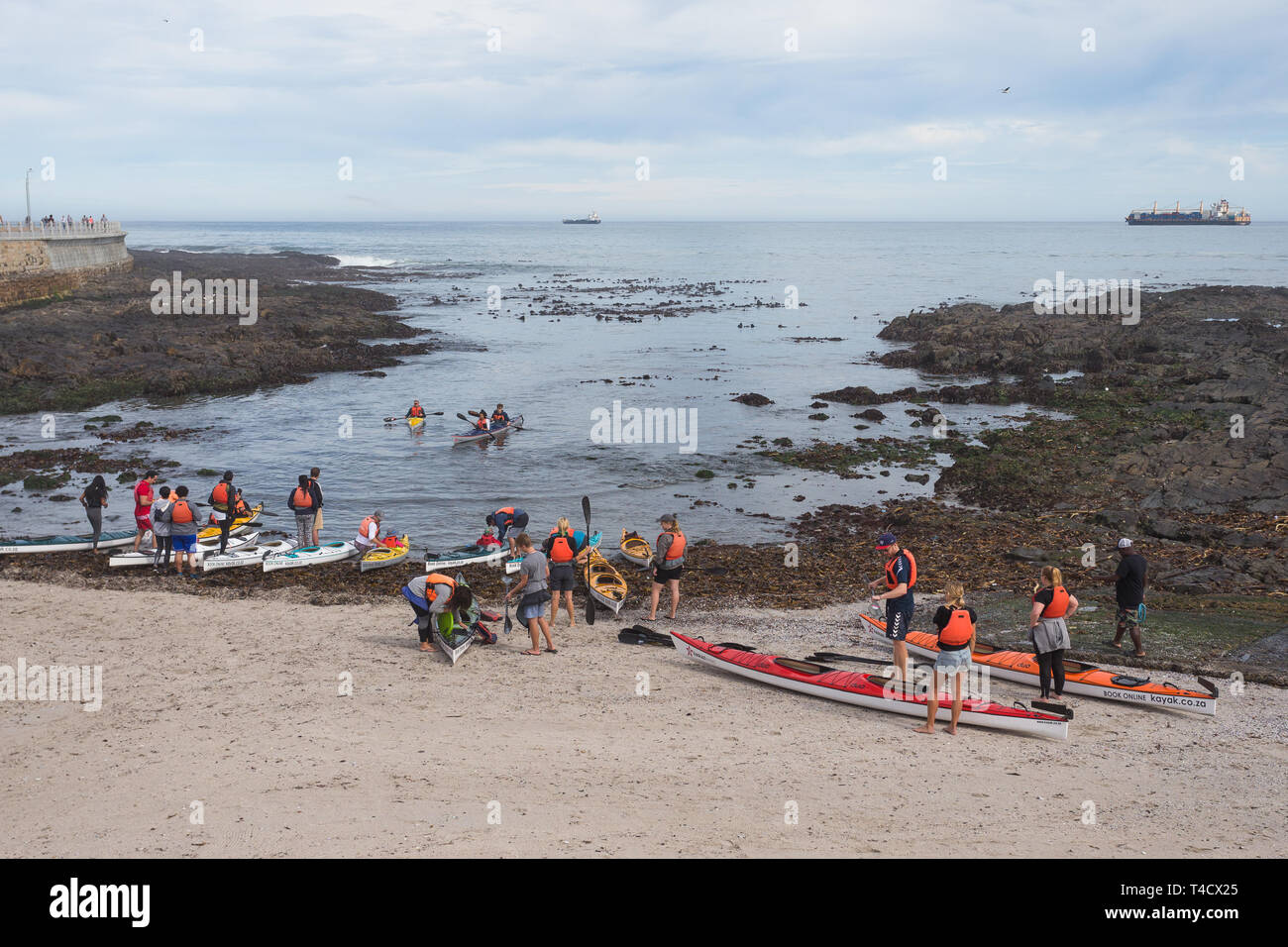 Regardant vers le bas sur un groupe de touristes de se préparer pour une excursion sur l'océan des kayaks ou canoës pendant les vacances d'été à Cape Town, Afrique du Sud Banque D'Images