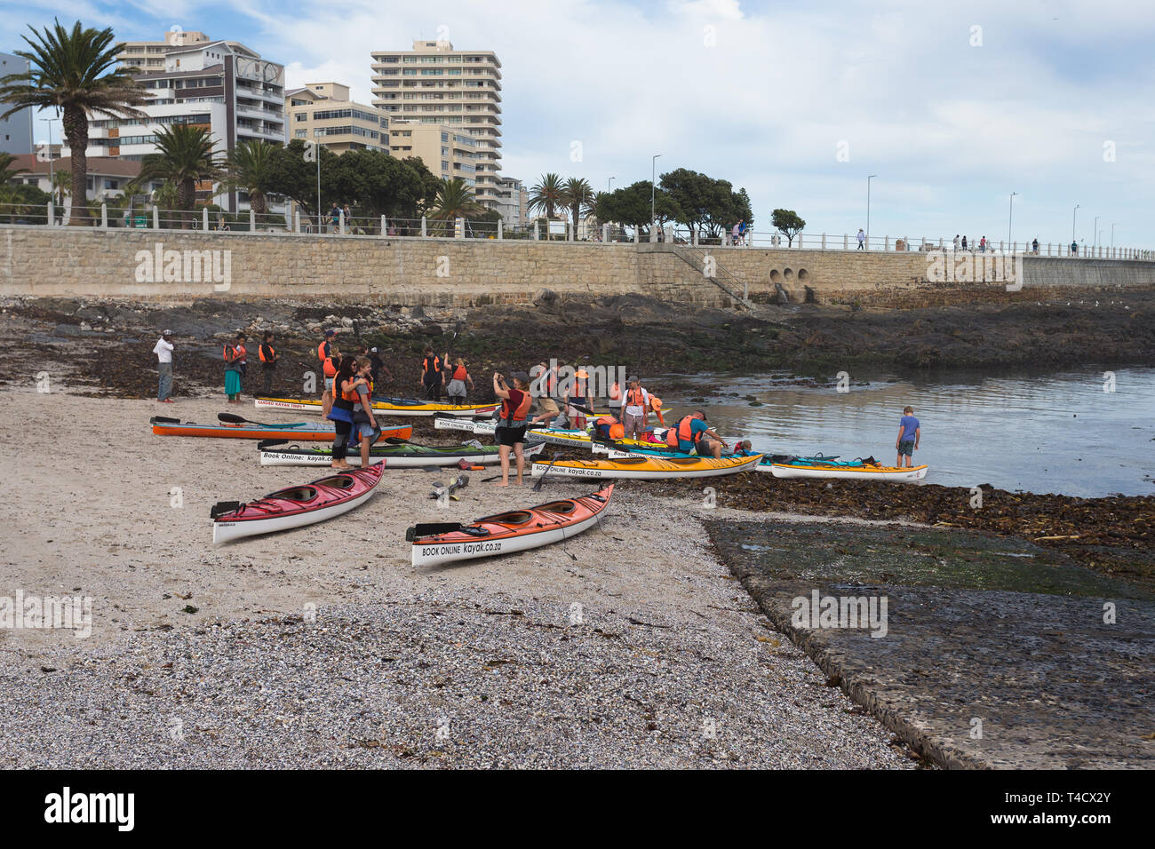 Les touristes au Cap de prendre des photos de l'autre avant qu'ils entrent dans leurs kayaks pour un aller-retour excursion sur l'océan pendant les vacances d'été Banque D'Images