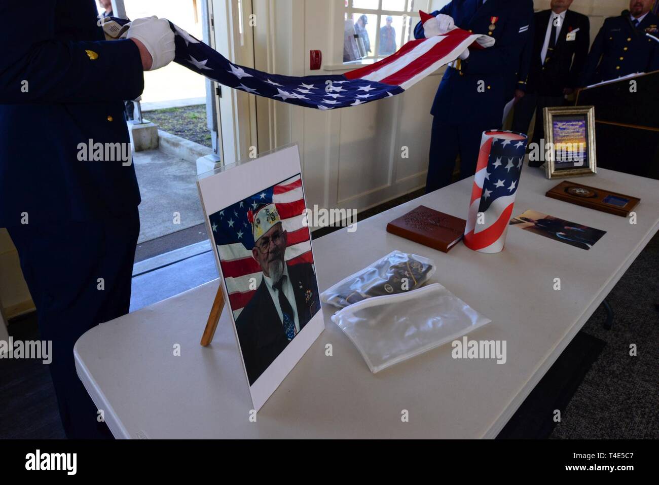 Les membres de la station de la Garde côtière canadienne Cape déception sur la garde d'honneur fois un drapeau américain en vue de le présenter à la famille pendant un service commémoratif pour Gordon Huggins à Barbey Maritime Centre à Astoria, Oregon, le 30 mars 2019. La cérémonie de pliage du drapeau est une tradition à certains militaires des funérailles et les services commémoratifs dans lequel 13 plis sont faits dans un drapeau américain, chacune avec une signification spéciale Banque D'Images