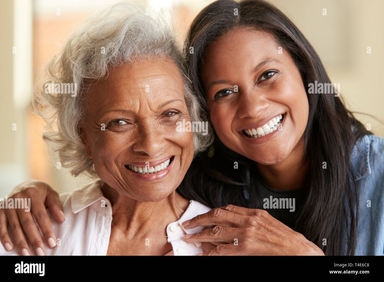 Portrait of Senior mère câlins par sa fille adulte à la maison Banque D'Images