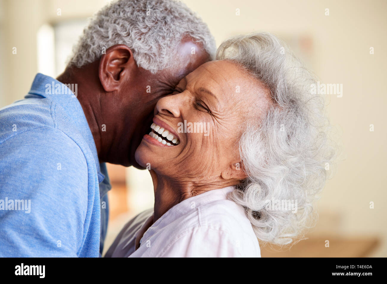 Tourné de profil senior Couple Hugging At Home Together Banque D'Images