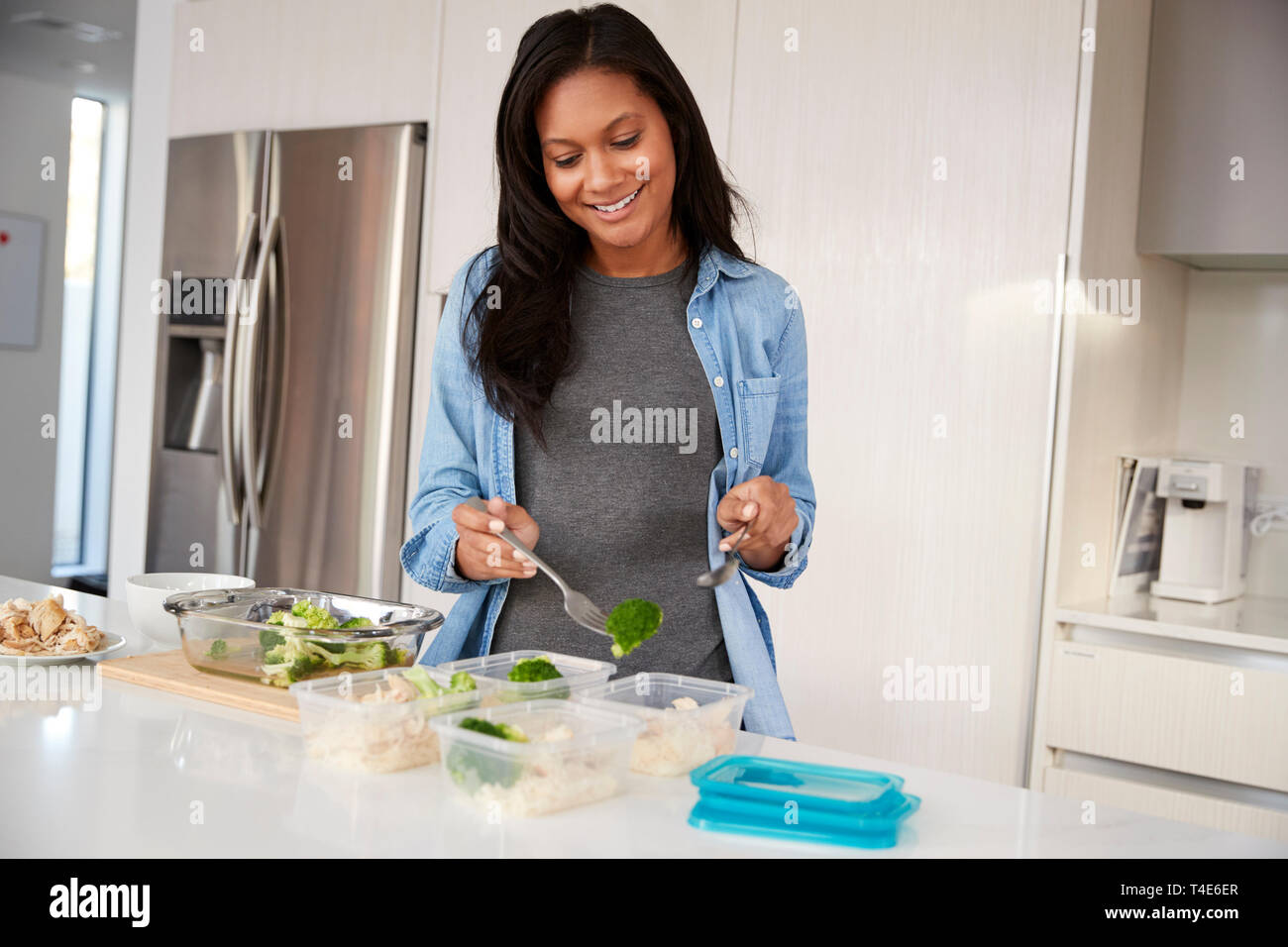 Femme dans la cuisine préparer le repas à haute teneur en protéines et de mettre dans des contenants en plastique Banque D'Images