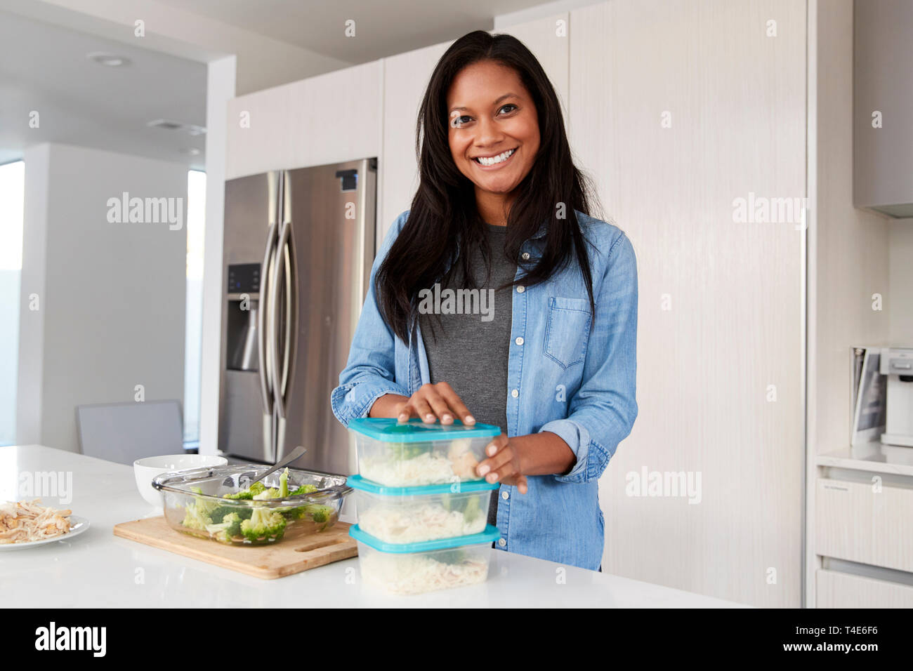 Portrait de femme dans la cuisine préparer le repas à haute teneur en protéines et de mettre certaines parties dans des conteneurs Banque D'Images