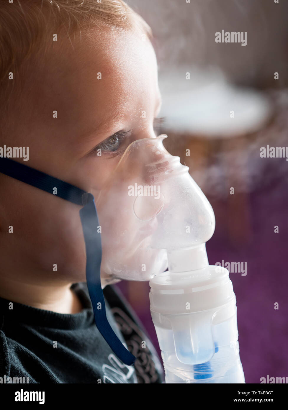 Petit enfant de race blanche l'inhalation à la maison avec un masque à oxygène Banque D'Images