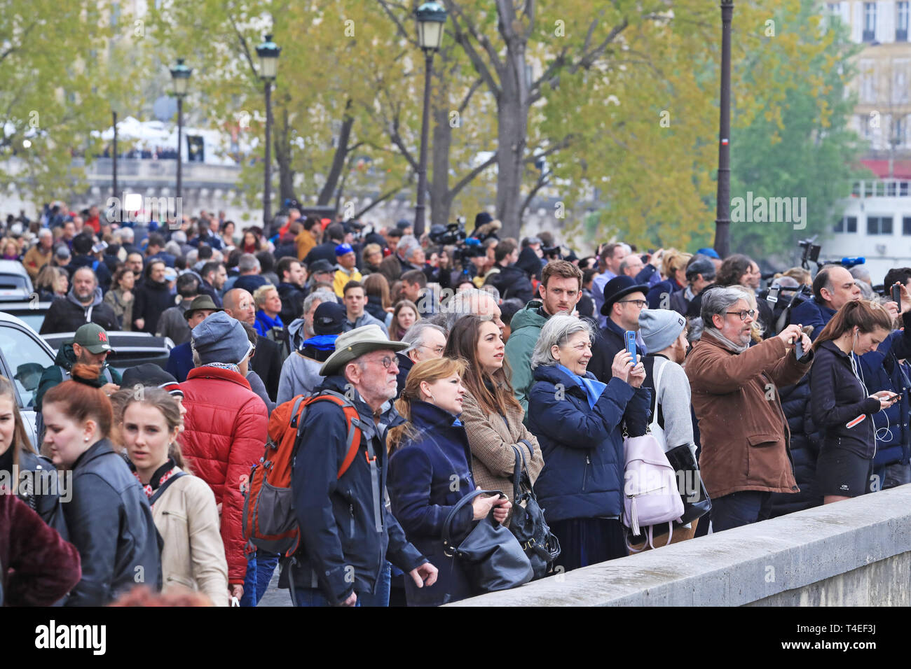 Une foule de personnes regarder vers le reste de la Cathédrale Notre Dame de Paris à la suite d'un incendie qui détruit une grande partie de l'immeuble dans la soirée de lundi. Banque D'Images