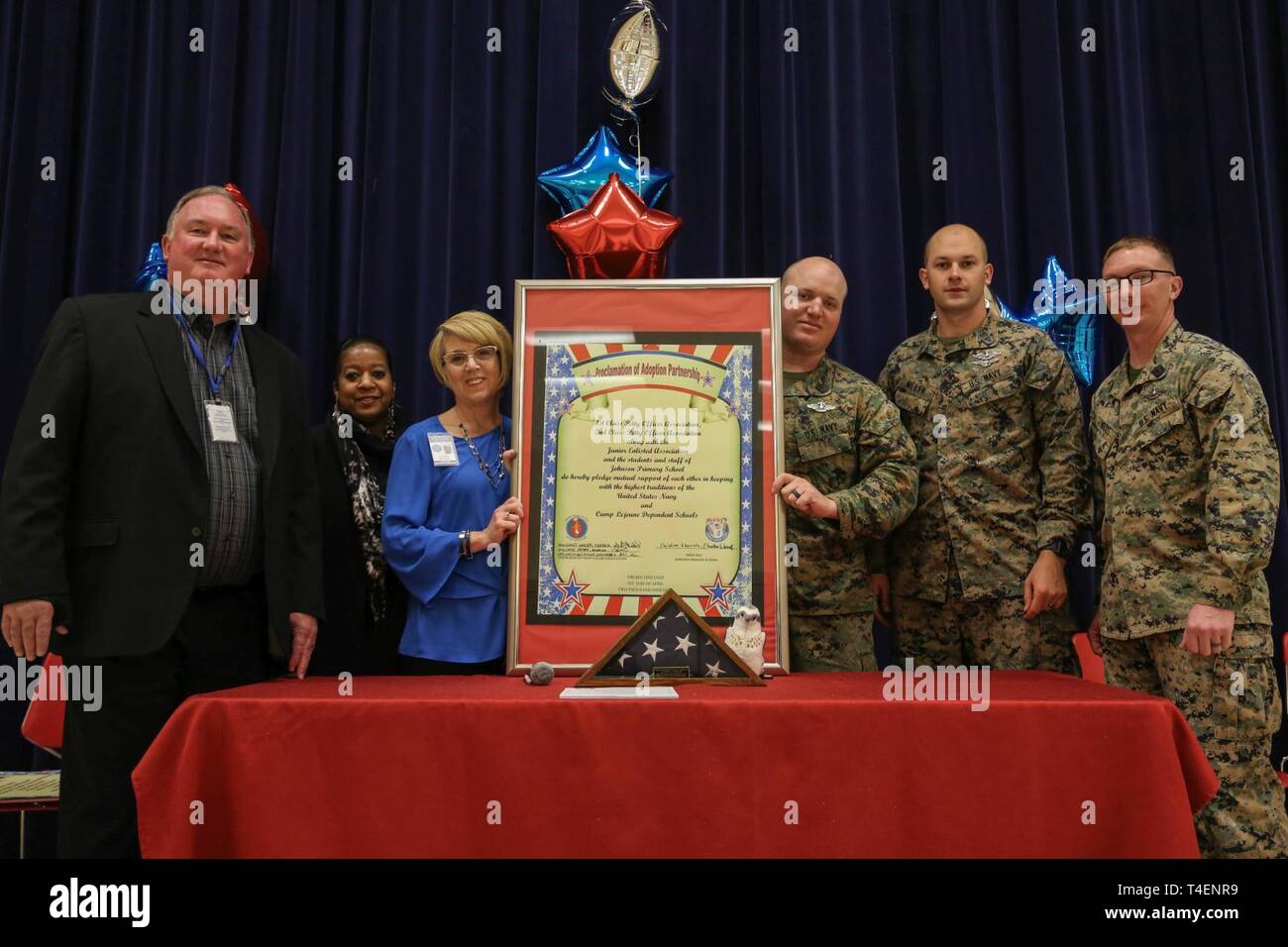 De gauche, Todd, Curkendall Monica Harvey, Dr Christine Sherretz, HM2 Nicholas Peters, HM3 Christopher Miller et HM1 Derrick Woods posent pour une photo avec l'adoption de la proclamation signée Johnson sur l'école primaire Camp Lejeune, en Caroline du Nord, le 1er avril. Le programme Adoptez une école a été mis en œuvre pour aider à développer une relation mutuellement bénéfique entre le personnel militaire et les écoles locales. Banque D'Images