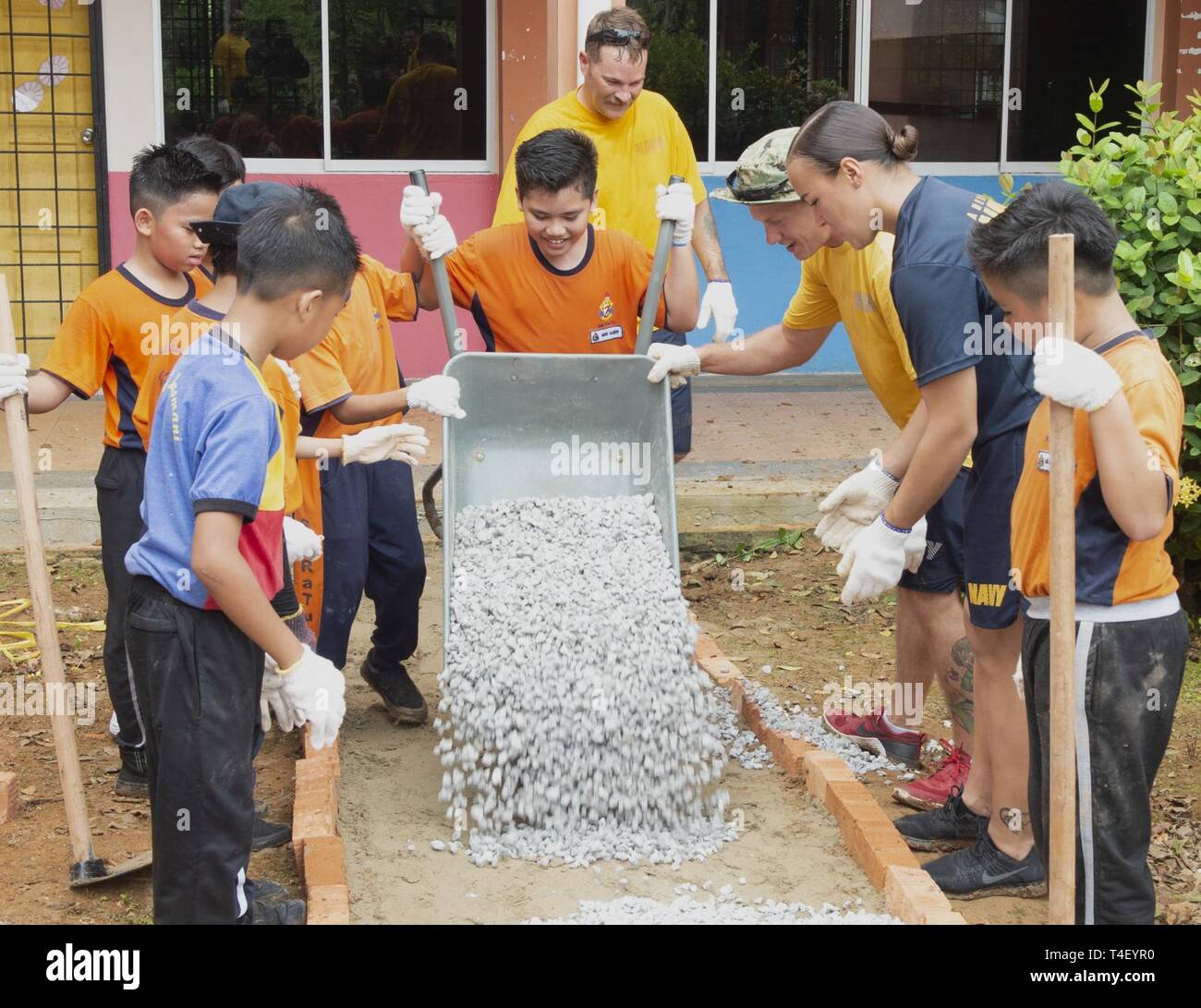 Malaisie (8 avril 2019) - élèves et Pacific Partnership 2019 bénévoles apportent dans le sable, les pierres et briques pour créer une passerelle au cours d'une rénovation cour Tupong à Rakyat école élémentaire. Ces engagements de promouvoir la coopération et l'amitié entre les participants et de partenariat du Pacifique 2019 la nation hôte. Partenariat du Pacifique, maintenant dans sa 14e version, est la plus grande multinationale annuelle l'aide humanitaire et des secours de la protection civile mission menée dans l'Indo-Pacifique. Chaque année, l'équipe de la mission travaille en collaboration avec d'accueillir et les pays partenaires à renforcer la interopera Banque D'Images