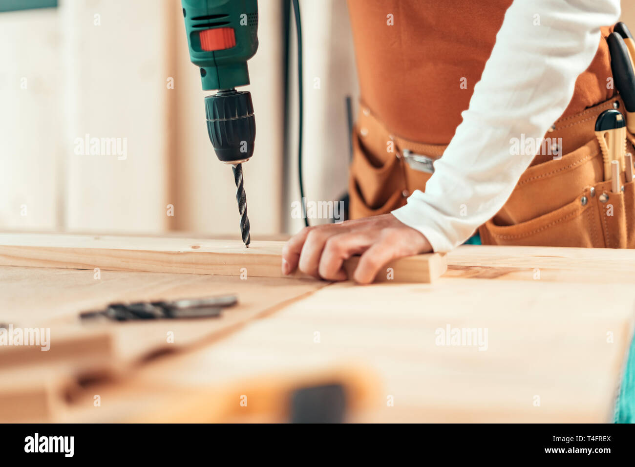 Female carpenter en utilisant la perceuse électrique en atelier de menuiserie ébénisterie, selective focus Banque D'Images