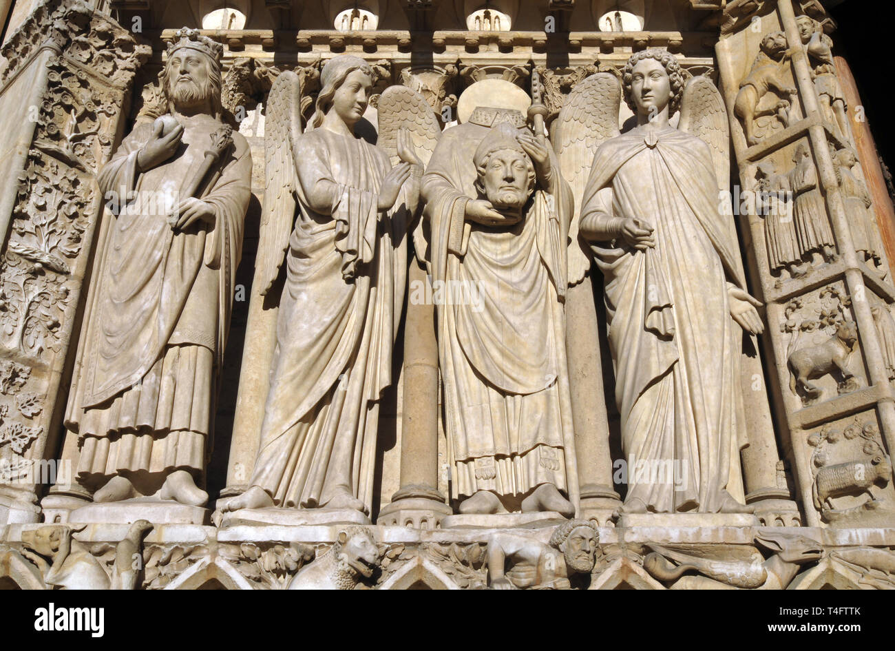Détail de sculptures sur la façade de la cathédrale Notre-Dame de Paris à Paris, France, y compris celle du martyr Saint Denis tenant sa tête. Banque D'Images