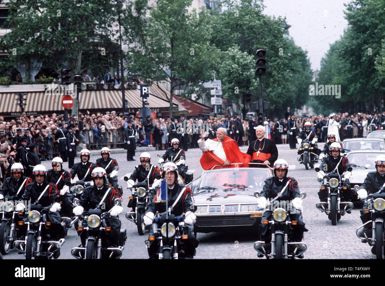 Le Pape Jean Paul II lors de sa visite historique à Paris en 1980 voyages en cortège de lumière avec un minimum de sécurité de voiture à toit ouvert avec escorte de police nerg tiques moto Banque D'Images