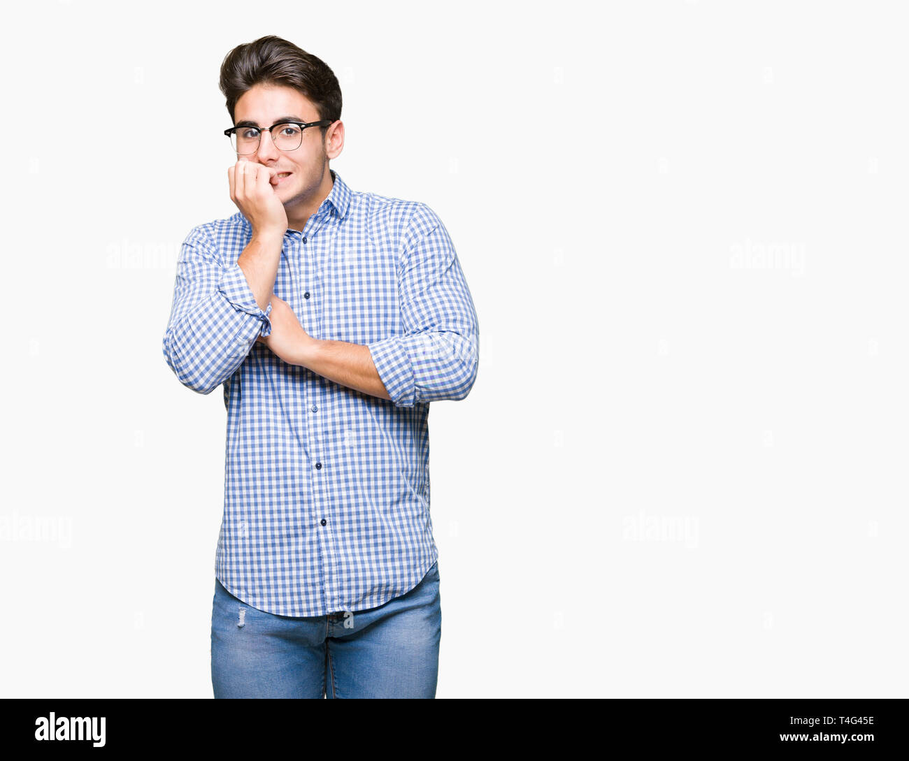 Beau jeune homme portant des lunettes au fond isolé à souligné et nerveux avec les mains sur la bouche de mordre les ongles. Problème d'anxiété. Banque D'Images