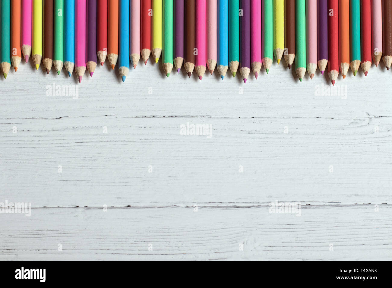 Crayons de couleur sur un fond de bois de la frontière, avec copie espace Banque D'Images