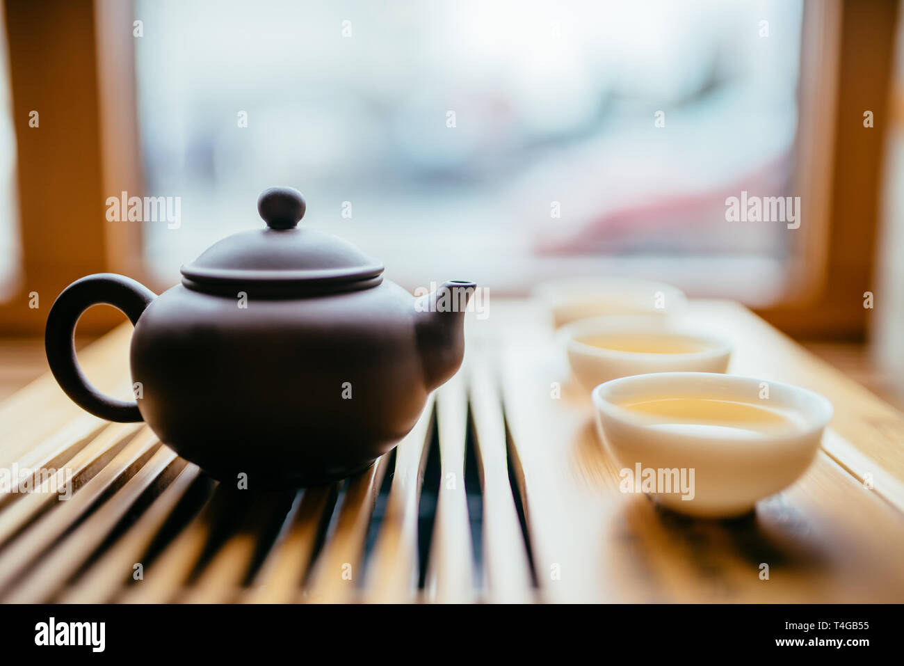 Théière et tasses à thé chinois près de fenêtre sur la table pour la cérémonie du thé Banque D'Images