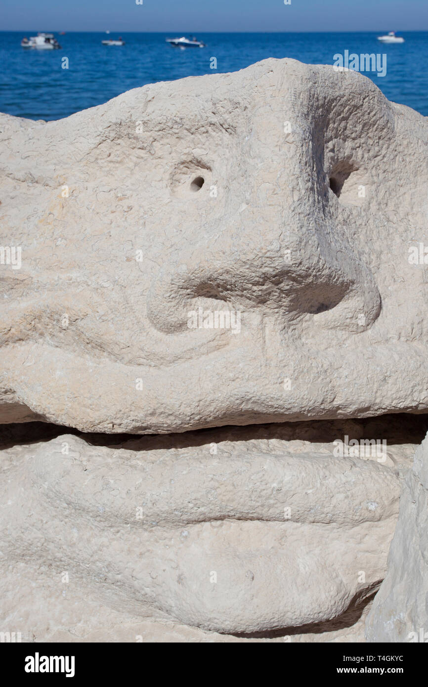 Grand visage sculpté dans la roche sur une jetée Banque D'Images