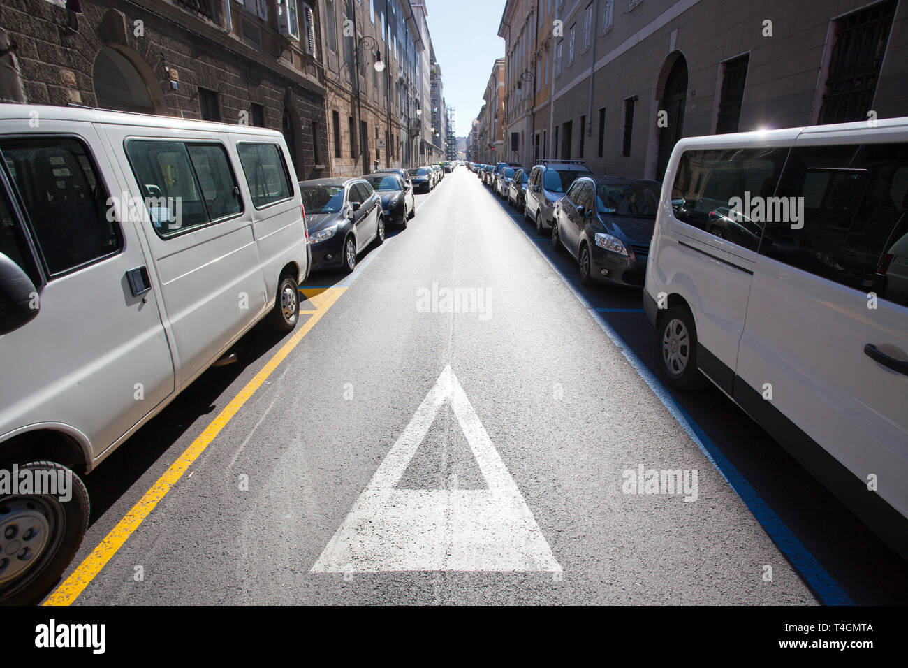 Voitures garées dans une rue étroite à Trieste, Italie Banque D'Images