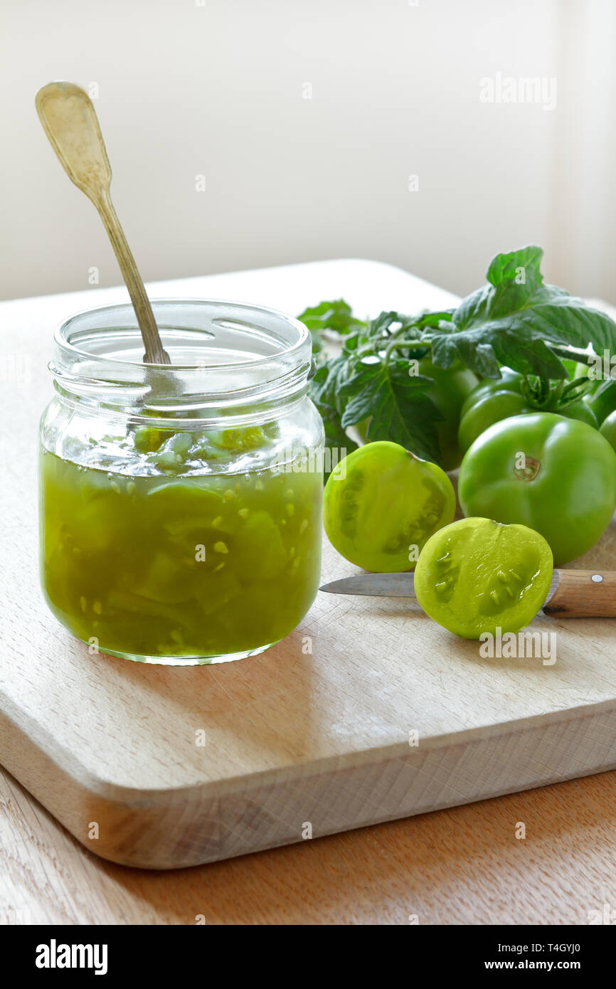Confiture de tomate verte ou savourer dans un bocal en verre avec une cuillère, vintage accueil concept mise en conserve Banque D'Images