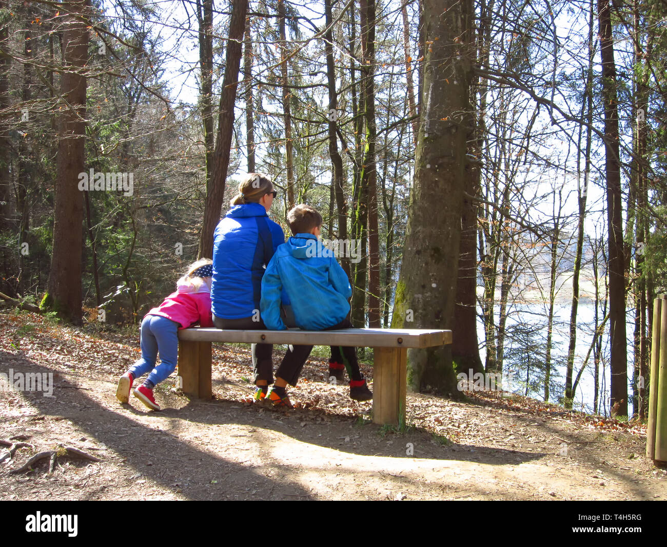 Mère heureuse avec son fils et sa fille assise sur un banc et regarder une belle vue sur la forêt Banque D'Images