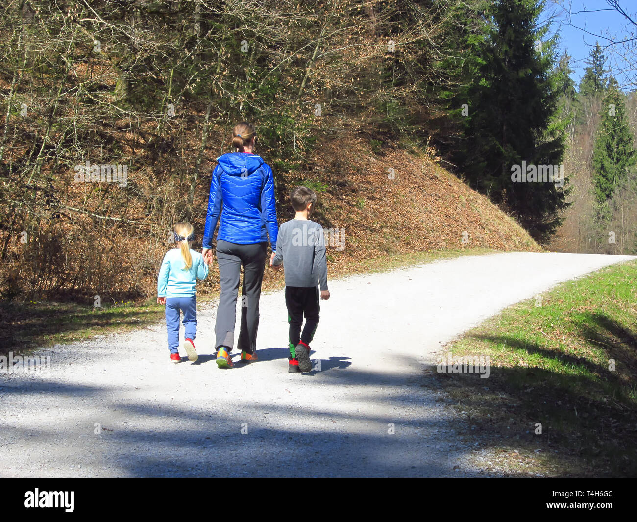 Mère avec son fils et sa fille randonnées et s'amuser et être heureux ensemble et tenir la main. Voyage en famille dans une forêt au printemps. Banque D'Images