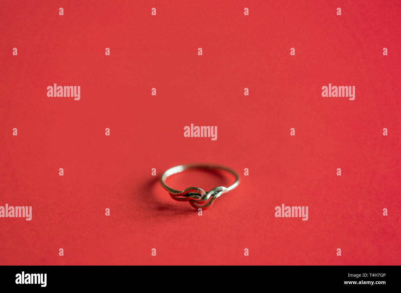 Close up / macro d'une bague en or sur fond de couleur rouge corail Banque D'Images