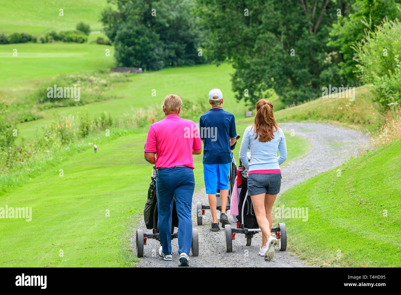 Golf de la famille sur le chemin de vol sur fairway Banque D'Images