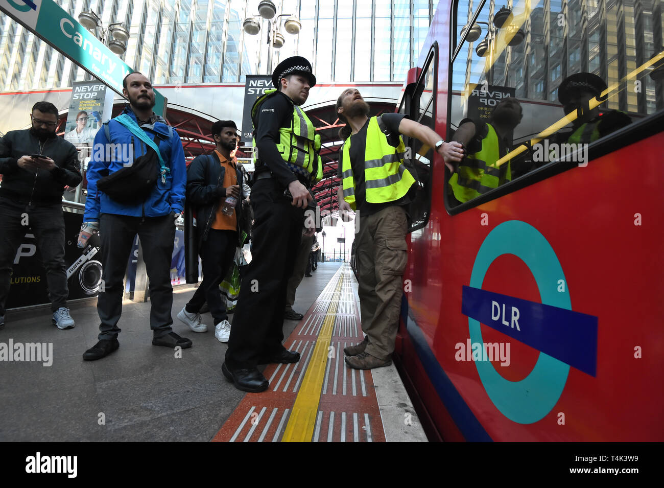 Un activiste climatique parle de policier après qu'il lui-même collé à un Dockland Light Railway à Canary Wharf gare de l'Est de Londres dans le cadre des manifestations du changement climatique dans la capitale. Banque D'Images