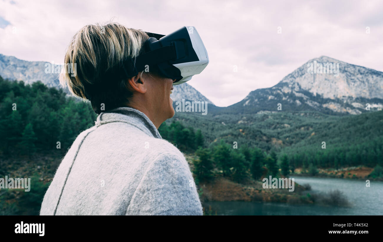 Femme dans la nature portant des lunettes de réalité augmentée.femelles adultes de s'amuser avec AR lunettes. L'avion. Lecture.la journée. Banque D'Images