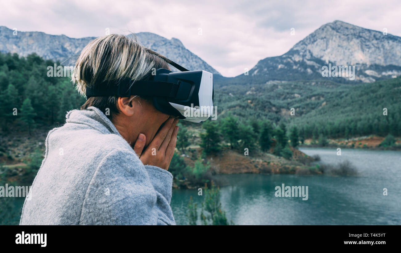 Femme dans la nature portant des lunettes de réalité augmentée.femelles adultes de s'amuser avec AR lunettes. L'avion. Lecture.la journée. Banque D'Images Femme dans la nature portant des lunettes de réalité augmentée.femelles adultes de s'amuser avec AR lunettes. L'avion. Lecture.la journée. Banque D'Images