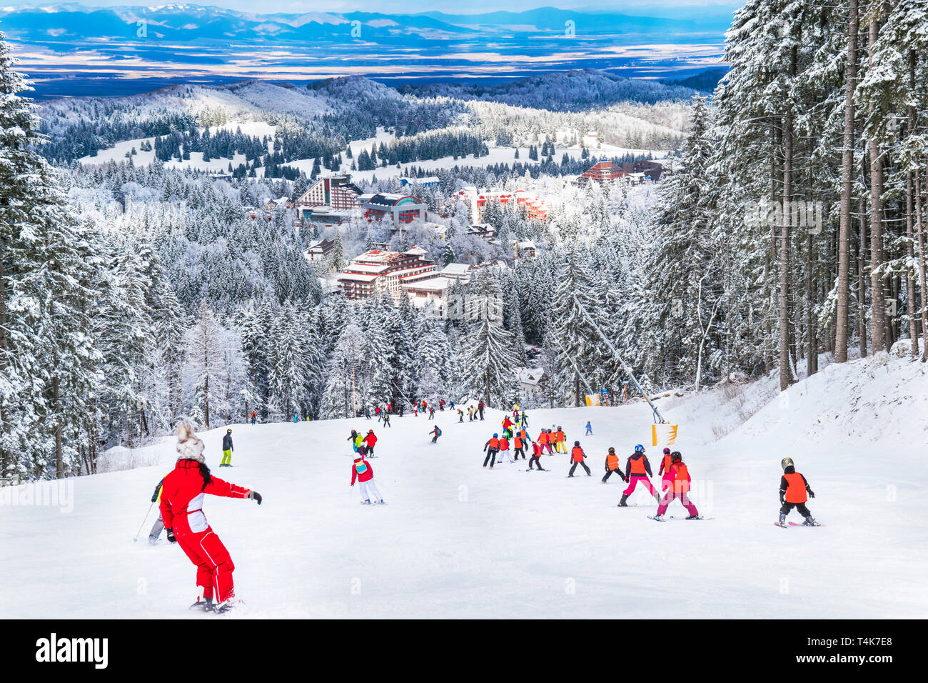 Groupe de jeunes sur une piste de ski en hiver, célèbre attraction touristique balnéaire de Poiana Brasov, Roumanie Banque D'Images