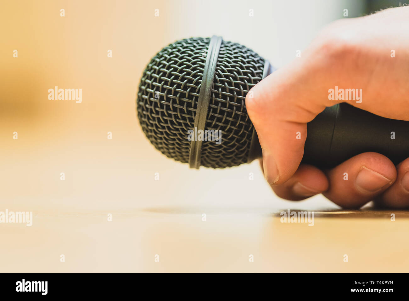 Close up photo d'une main qui maintient un microphone noir. Banque D'Images