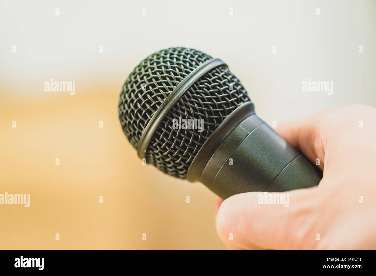 Close up photo d'une main qui maintient un microphone noir. Banque D'Images