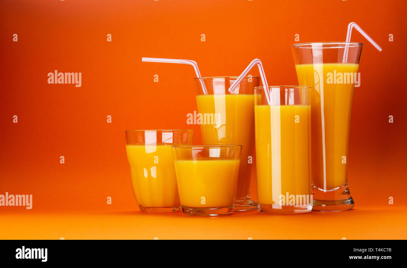 Verres de jus d'orange isolé sur fond orange couleur avec copie espace pour texte, cocktail d'agrumes frais Banque D'Images